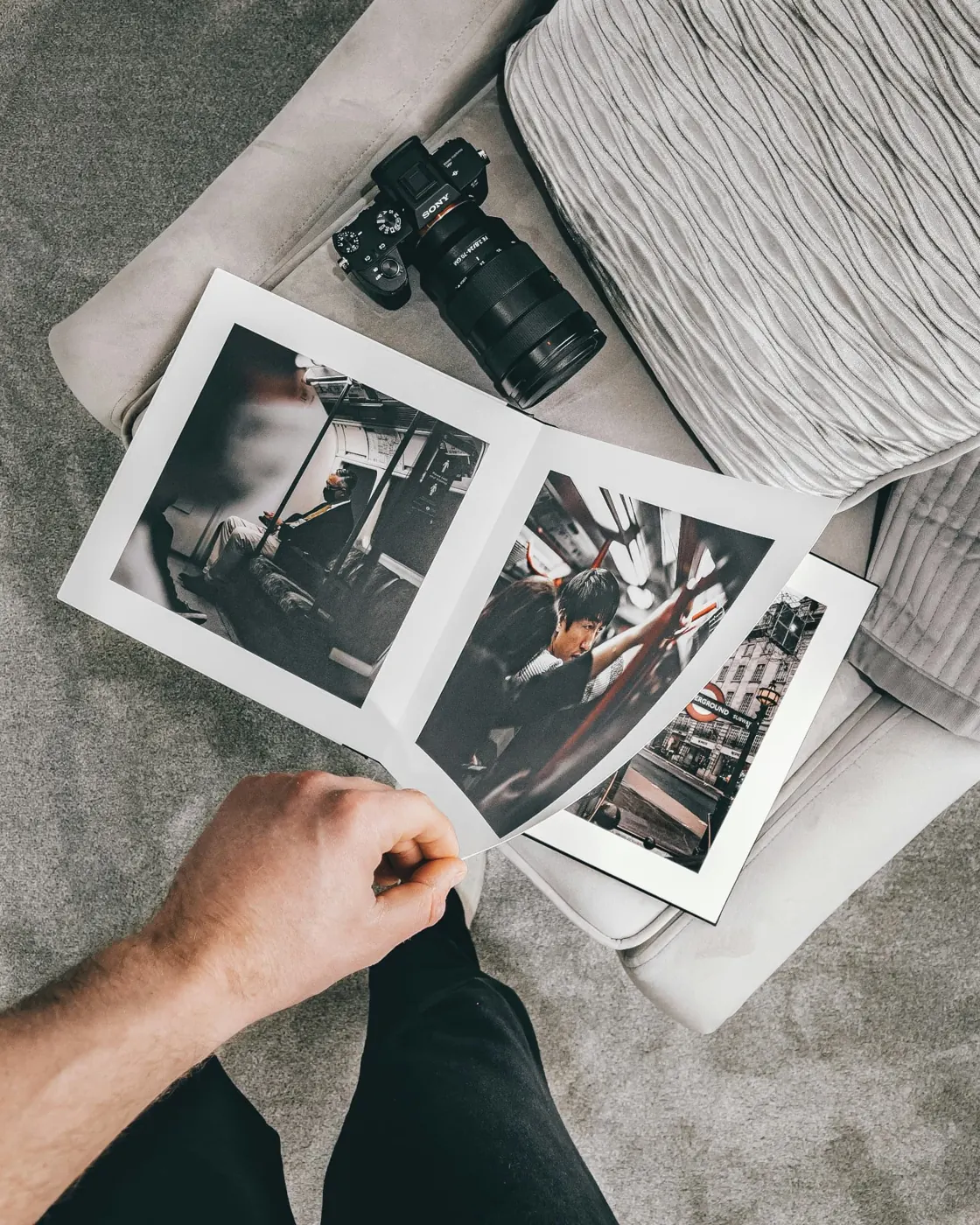 A photo book open beside a camera and loose printed photographs